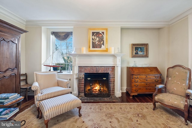 sitting room featuring crown molding, a fireplace, and wood-type flooring