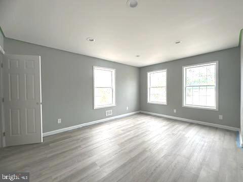 empty room with baseboards and wood finished floors