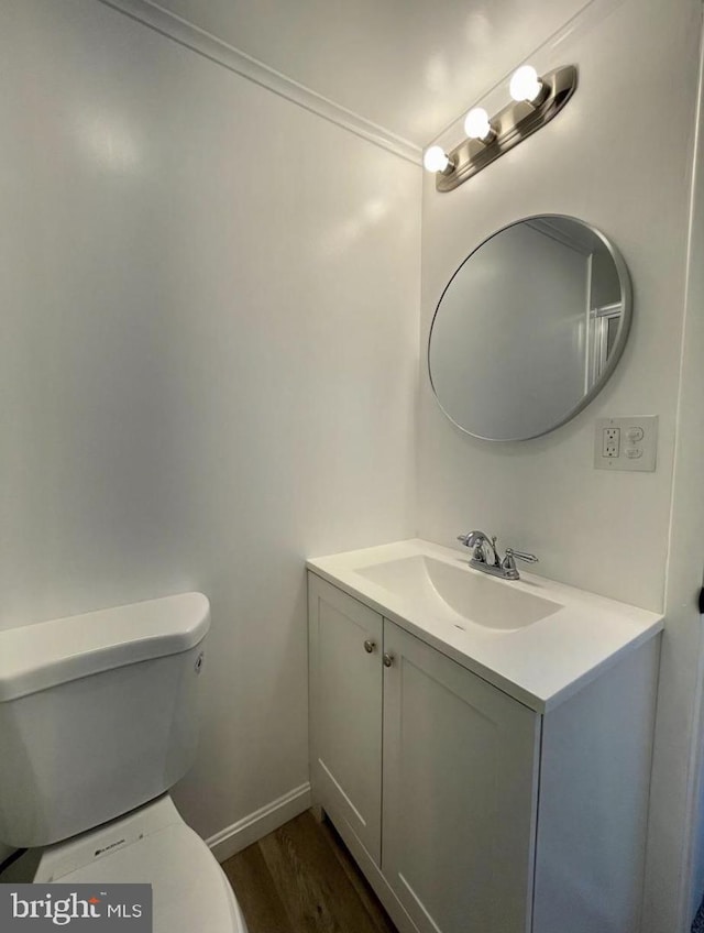 bathroom with hardwood / wood-style floors, vanity, and toilet