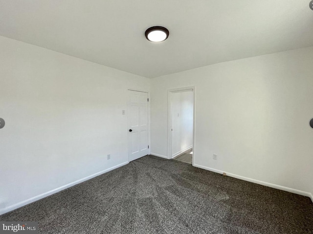 empty room featuring dark colored carpet