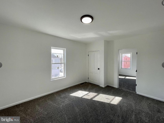 unfurnished bedroom with dark colored carpet