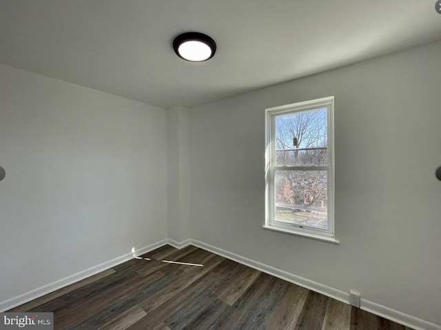 unfurnished room with dark wood-type flooring