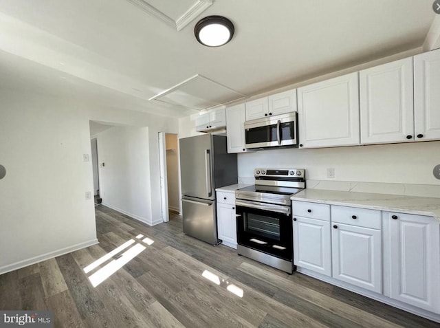 kitchen featuring light stone counters, white cabinetry, stainless steel appliances, and dark wood-type flooring