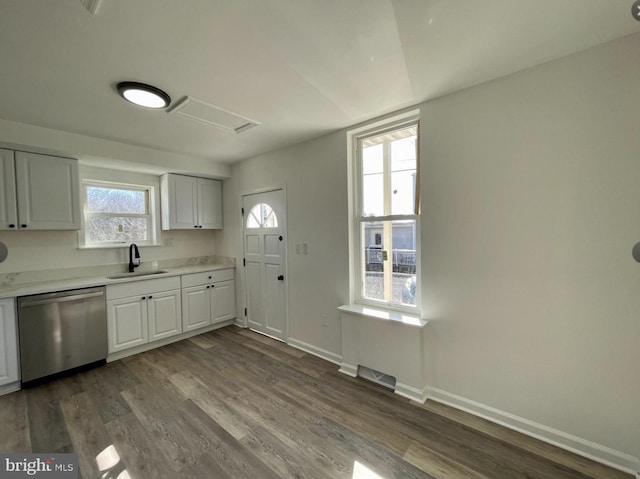 kitchen with stainless steel dishwasher, sink, white cabinets, and dark wood-type flooring