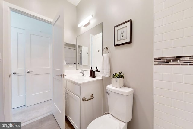 bathroom with tile floors, toilet, and vanity