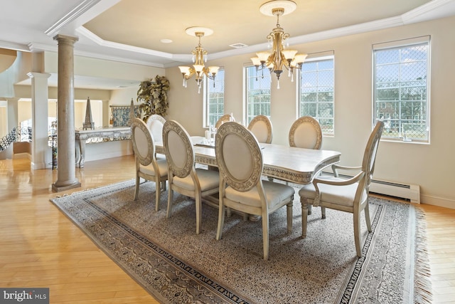 dining room featuring a chandelier, ornate columns, and light hardwood / wood-style flooring