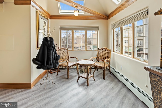 sitting room with light hardwood / wood-style floors, vaulted ceiling with skylight, and a wealth of natural light