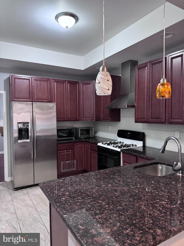 kitchen with appliances with stainless steel finishes, light tile floors, pendant lighting, wall chimney exhaust hood, and sink