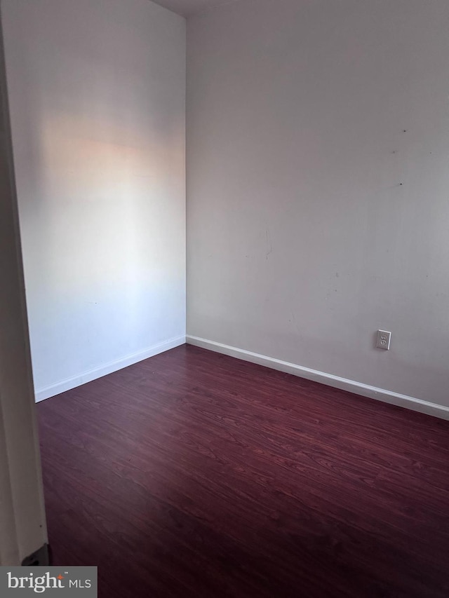 unfurnished room with dark hardwood / wood-style flooring