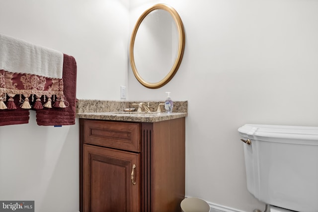 bathroom with toilet and large vanity