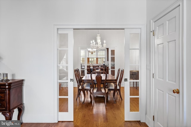 dining area featuring light hardwood / wood-style flooring and a chandelier