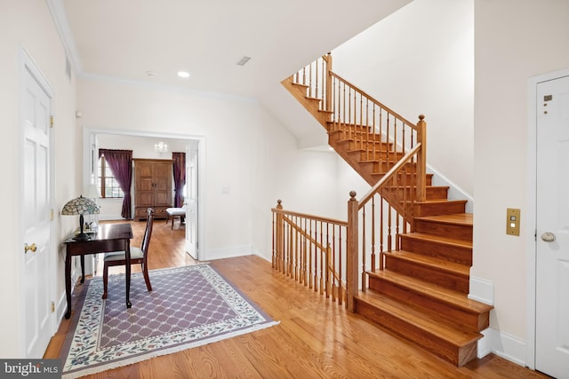 stairway featuring light hardwood / wood-style floors and crown molding