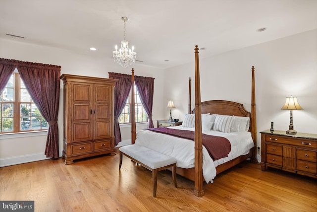 bedroom featuring a chandelier and light hardwood / wood-style floors