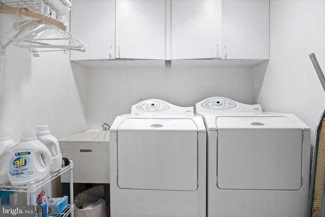 laundry room featuring washing machine and clothes dryer and cabinets