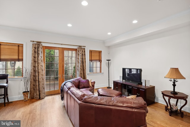 living room featuring crown molding, french doors, and light wood-type flooring