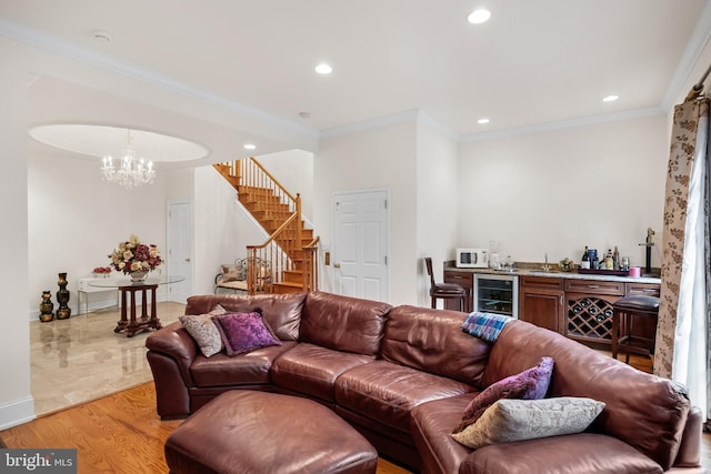 living room featuring beverage cooler, crown molding, an inviting chandelier, and light tile flooring