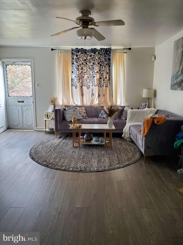 living room with ceiling fan and dark hardwood / wood-style flooring