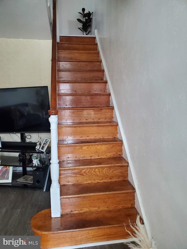 stairway featuring dark wood-type flooring