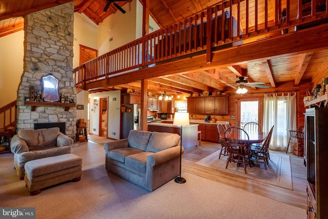 living room with beam ceiling, light wood-type flooring, high vaulted ceiling, and wood ceiling