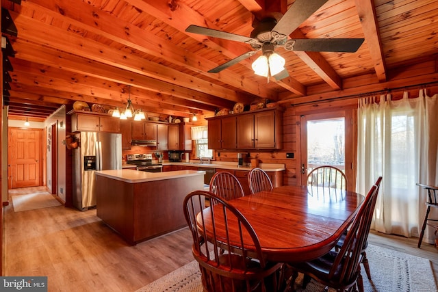 dining area with beamed ceiling, light hardwood / wood-style floors, wood walls, and wooden ceiling