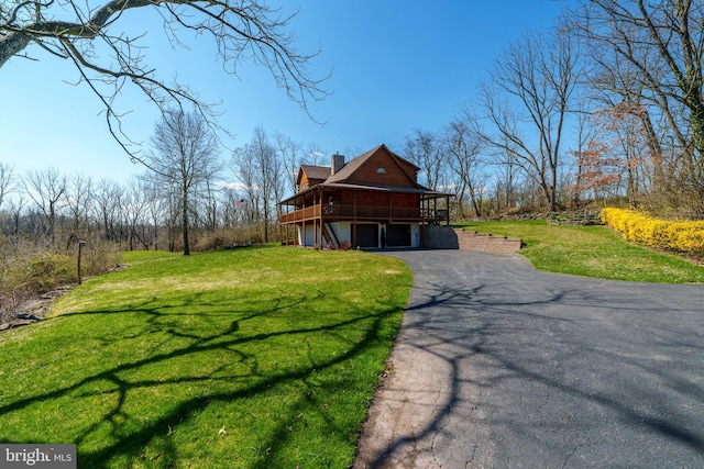 view of side of property with a wooden deck and a lawn