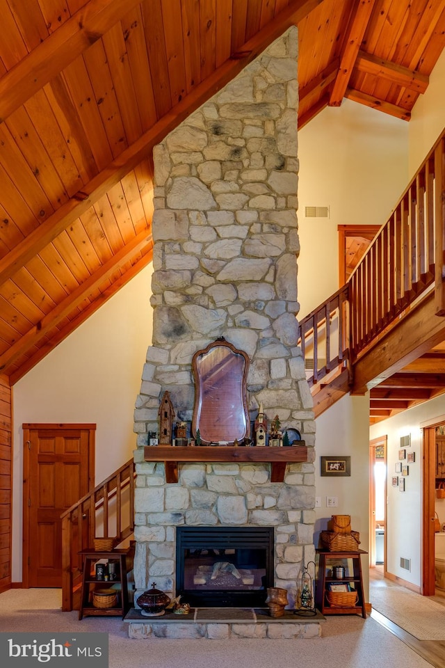 unfurnished living room featuring a fireplace, beamed ceiling, wooden ceiling, and high vaulted ceiling