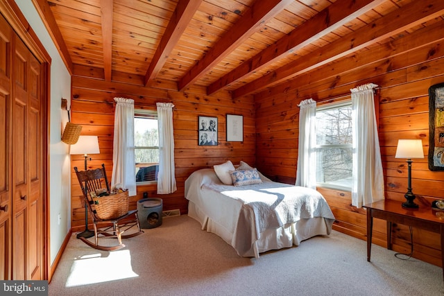 bedroom featuring beam ceiling, multiple windows, wooden walls, and wood ceiling