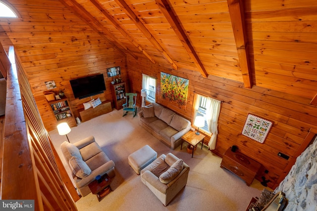 living room with vaulted ceiling with beams, carpet floors, wooden ceiling, and wood walls