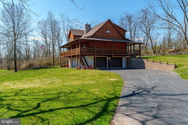 view of front facade with a garage, a wooden deck, and a front yard