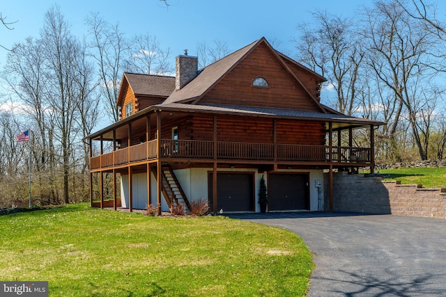 exterior space featuring a deck, a front yard, and a garage