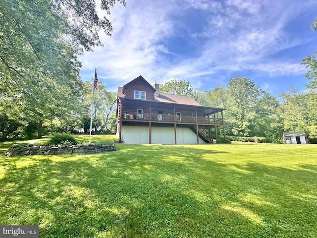 back of property with a wooden deck, a yard, and a storage shed