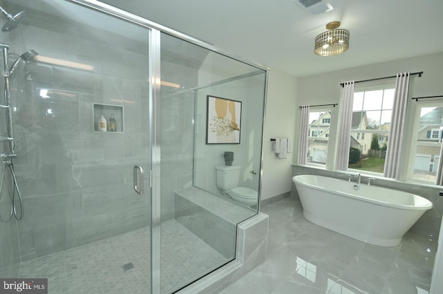 bathroom featuring plus walk in shower and toilet