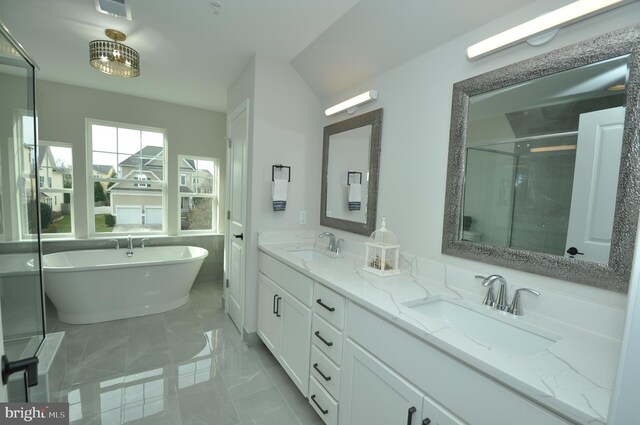 bathroom featuring vanity and independent shower and bath