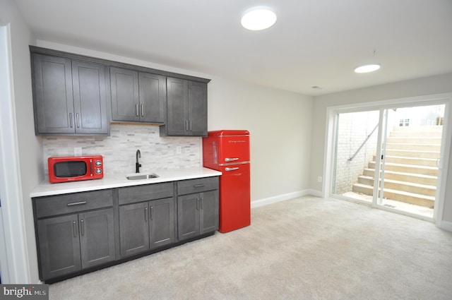 kitchen with tasteful backsplash, light carpet, sink, and dark brown cabinets