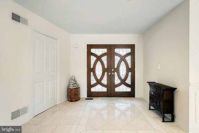 tiled foyer entrance featuring french doors