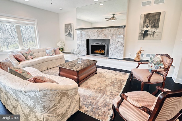 living room featuring ceiling fan and dark hardwood / wood-style floors