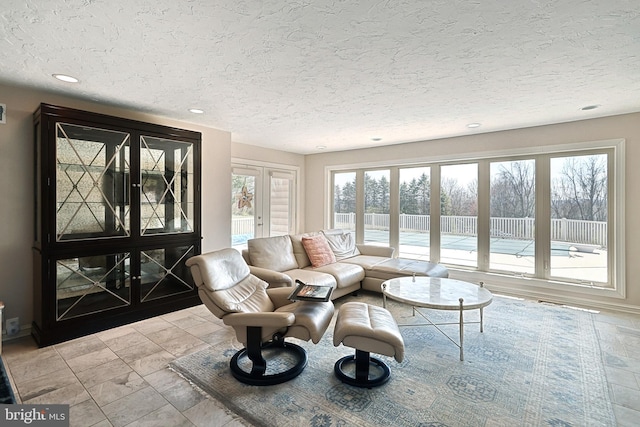 living room featuring french doors, a textured ceiling, and light tile floors