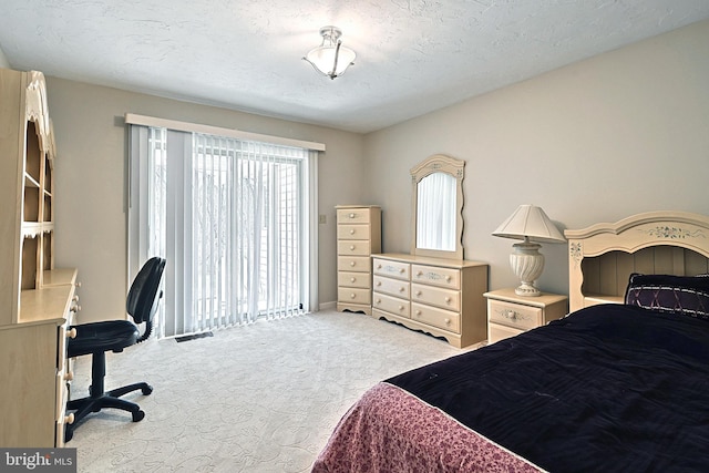 bedroom with light carpet and a textured ceiling