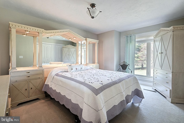 carpeted bedroom featuring a closet and decorative columns