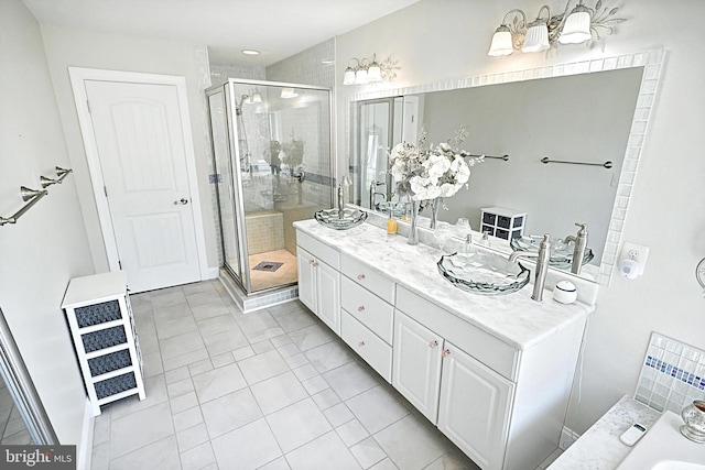 bathroom with tile flooring, large vanity, double sink, and a shower with shower door