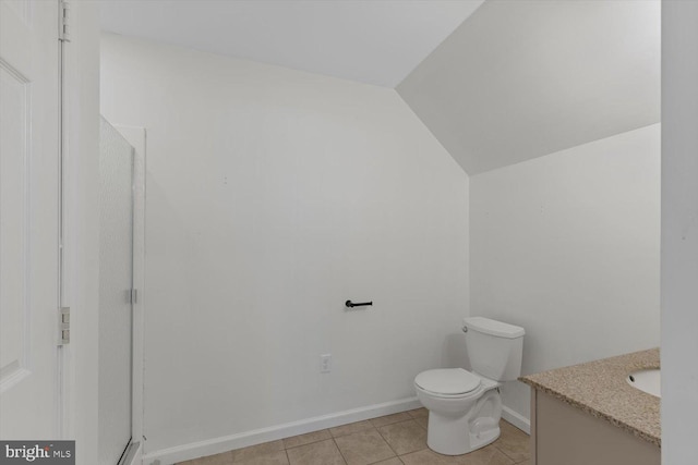 bathroom with vanity, vaulted ceiling, toilet, and tile flooring