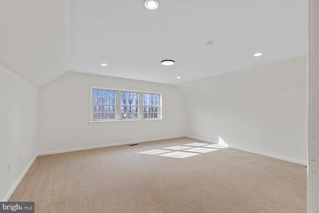 spare room with carpet and vaulted ceiling