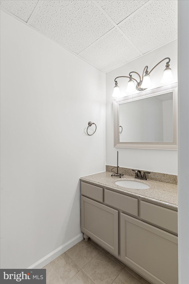 bathroom featuring a drop ceiling, tile flooring, and large vanity