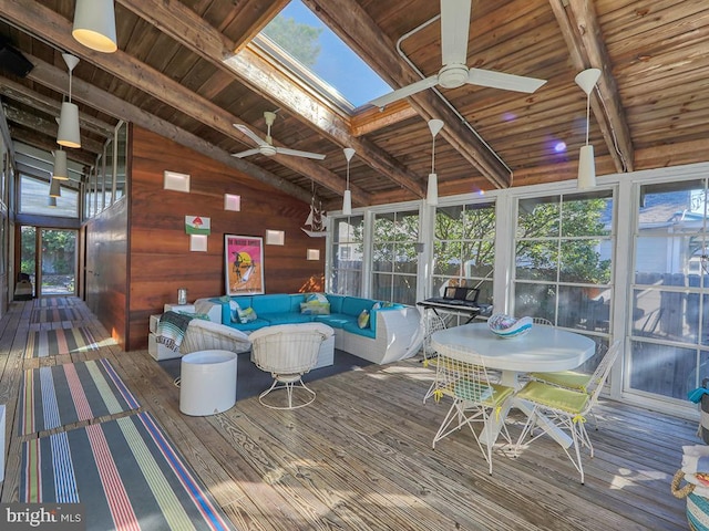 sunroom featuring lofted ceiling with skylight, plenty of natural light, and ceiling fan