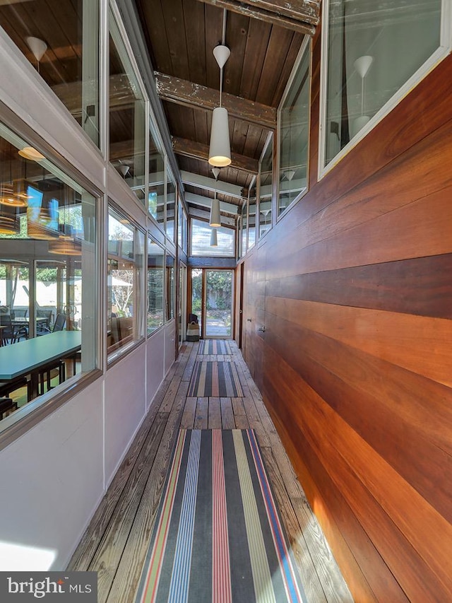 corridor featuring hardwood / wood-style flooring, wooden ceiling, and wooden walls