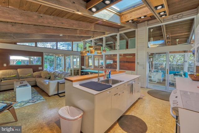 23 Jersey St, Dewey Beach, DE 19971 - kitchen featuring a sink, a kitchen island with sink, white electric range oven, open floor plan, and a skylight