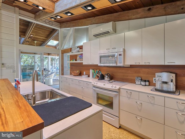 kitchen with lofted ceiling with beams, butcher block counters, white appliances, and a wall unit AC