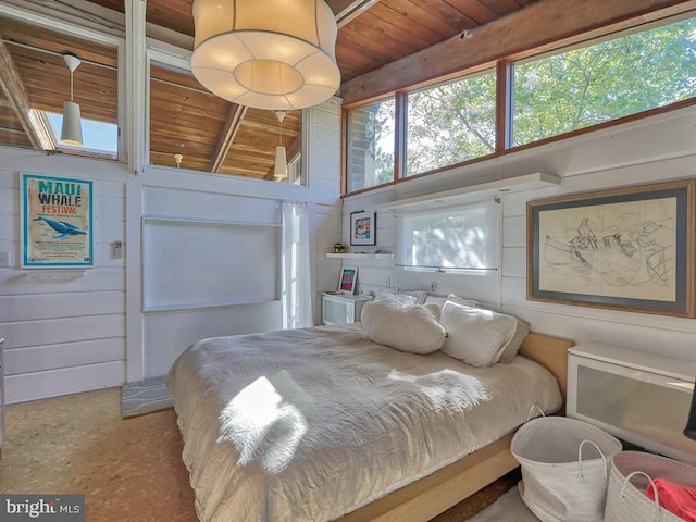 bedroom with concrete flooring, wooden walls, and wooden ceiling