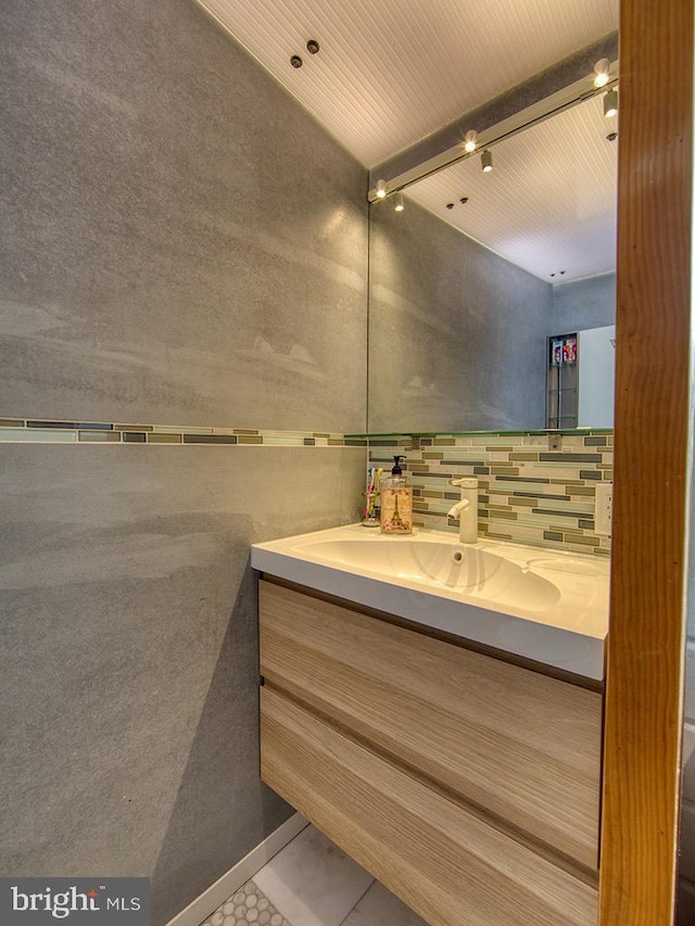 bathroom with vanity, tile patterned floors, and backsplash