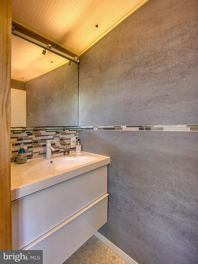 bathroom featuring vanity and backsplash